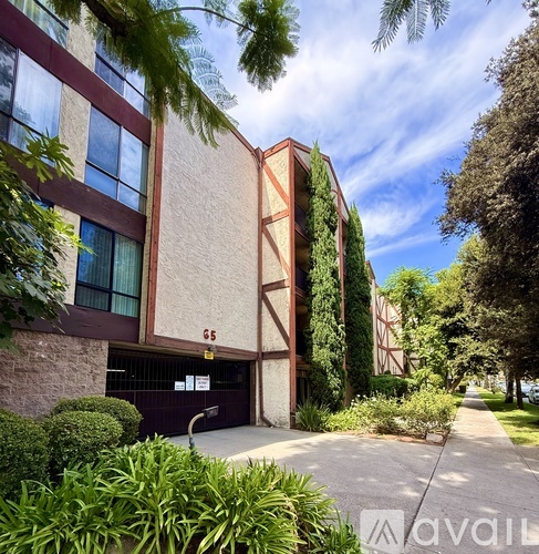 A building with the number 65 on it is surrounded by greenery.