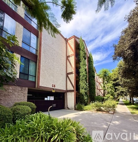 A building with the number 65 on it is surrounded by greenery.