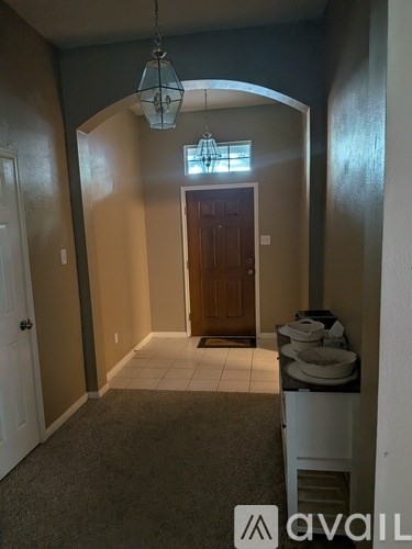 A hallway with a brown door and a white door on the left.