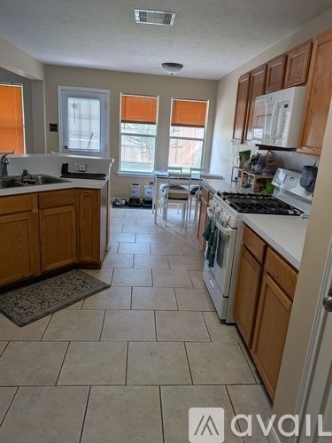 A kitchen with wooden cabinets and a tiled floor.