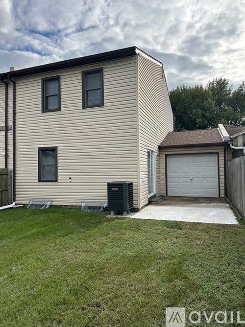 A two-story house with a garage and a small lawn in front.