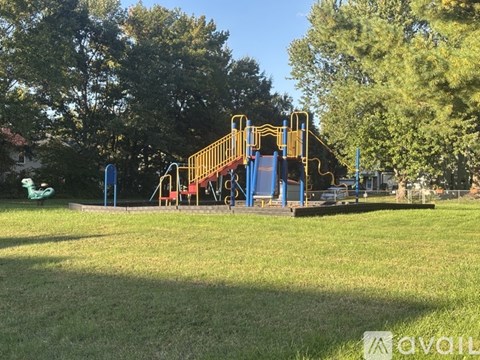 A playground with a yellow slide and a blue slide.