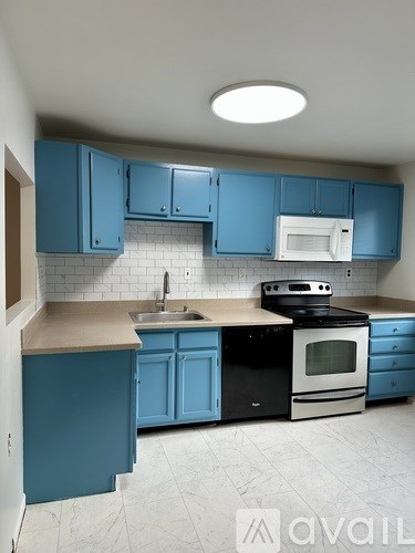 A kitchen with blue cabinets and appliances.