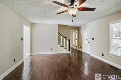 A spacious room with a staircase leading to the second floor.