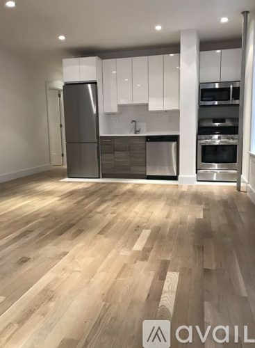 A kitchen with wooden floors and white cabinets.