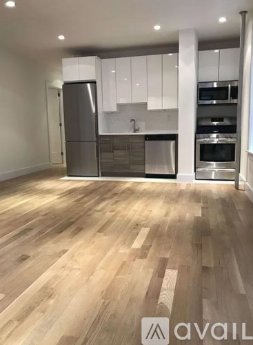A kitchen with wooden floors and white cabinets.
