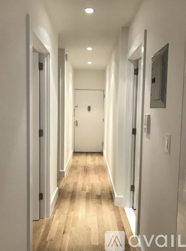 A long hallway with doors on both sides and a wooden floor.