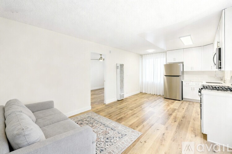 A living room with a grey sofa and a wooden floor.