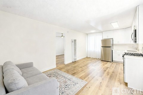A living room with a grey sofa and a wooden floor.