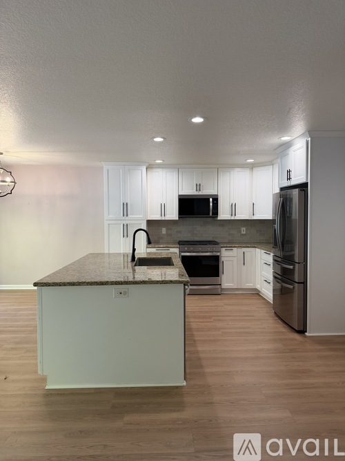 A kitchen with a granite countertop and stainless steel appliances.