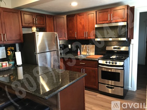A kitchen with wooden cabinets and a stainless steel refrigerator.