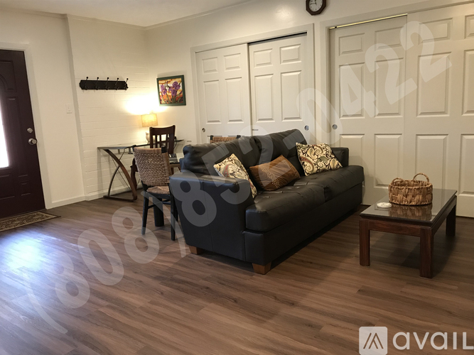 A living room with a dark sofa and a wooden floor.