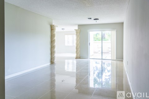 A spacious room with a marble floor and a large window.