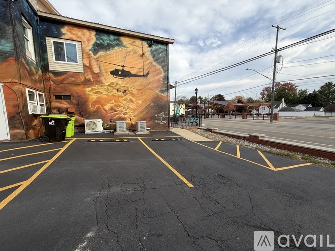 A wall with a mural of a helicopter and a building with a fire on it.