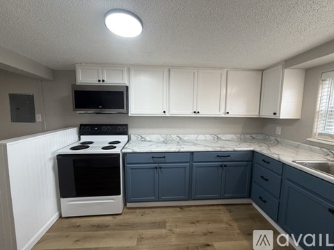 A kitchen with white cabinets and a black stove top oven.