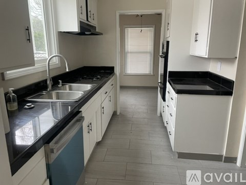 A kitchen with black countertops and white cabinets.