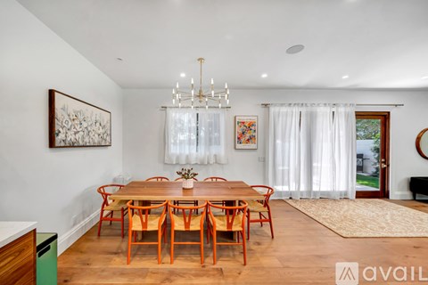 A dining room with a wooden table and chairs.