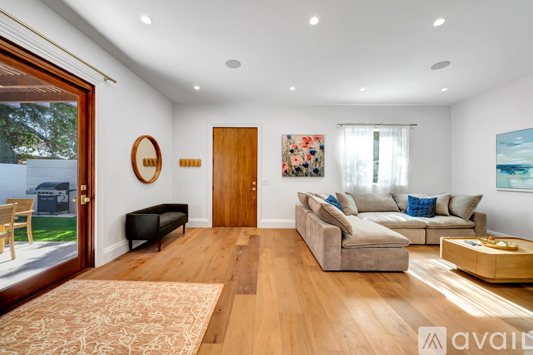 A living room with a couch, a coffee table, and a painting on the wall.