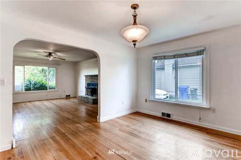 A room with wooden floors and a ceiling fan.