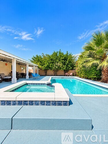 A pool with a white bench and a house in the background.