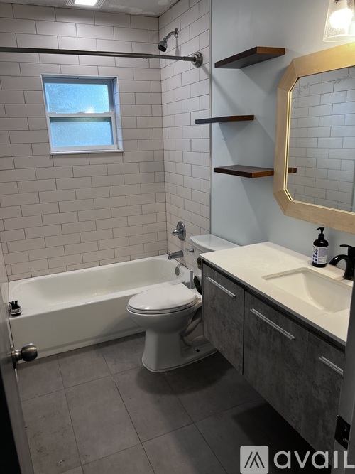 A bathroom with a white toilet, a bathtub, and a sink.