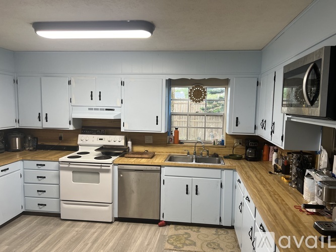 A kitchen with white cabinets and a wooden countertop.