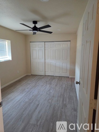 A room with a ceiling fan and a closed white door.