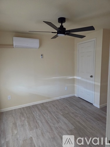 A room with a ceiling fan and a door.