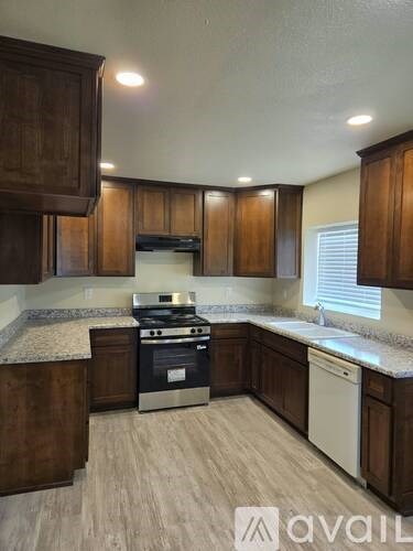 A kitchen with wooden cabinets and a stove top oven.