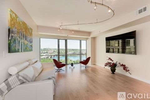 A living room with a large window overlooking a body of water.