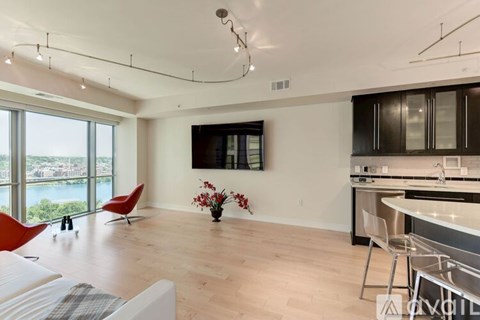 A modern kitchen with a red chair and a view of the water.