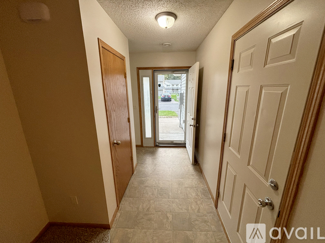 A hallway with a door on the right and a window on the left.