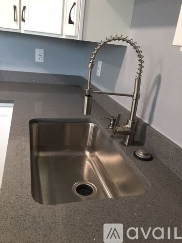 A modern kitchen sink with a chrome faucet.