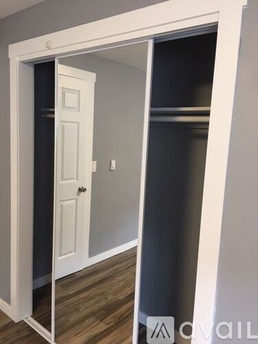 A white door is open to a dark room.