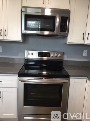 A kitchen with a stove top oven and microwave above it.