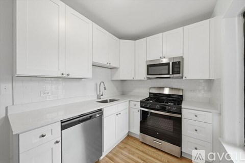 A kitchen with white cabinets and stainless steel appliances.