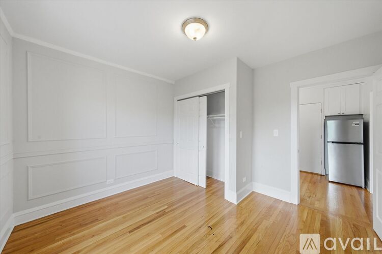 A spacious room with wooden floors and white walls.