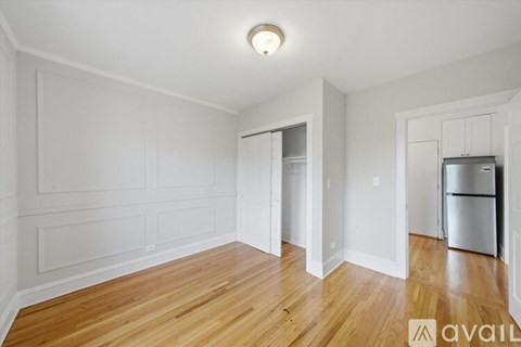 A spacious room with wooden floors and white walls.