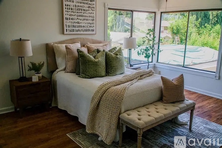 A bedroom with a large bed and a bench.