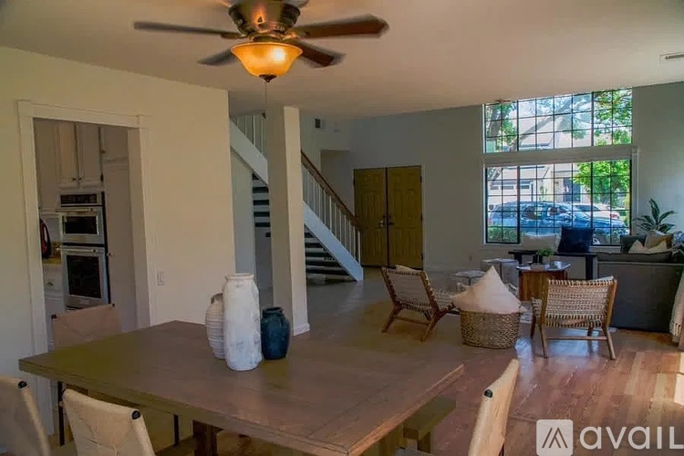 A dining room with a table and chairs and a ceiling fan.