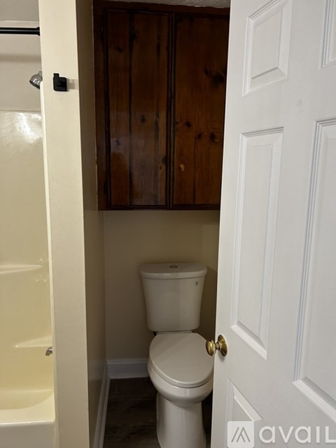A white toilet in a small bathroom with a white door.