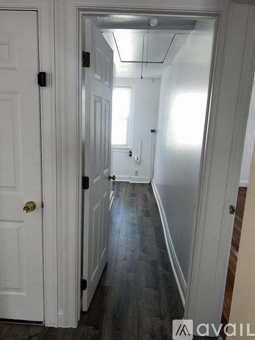 A hallway with a white door and a black door handle.
