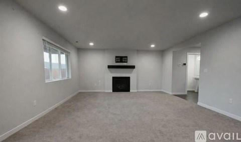 A spacious living room with a fireplace and a television.