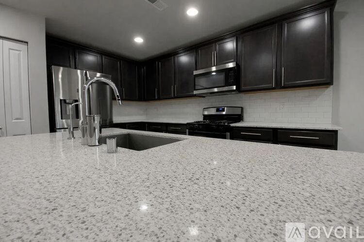 A kitchen with black cabinets and a white countertop.