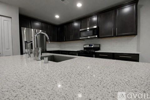 A kitchen with black cabinets and a white countertop.