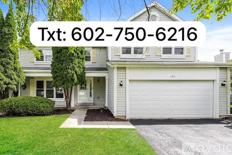 A house with a white garage door and a driveway leading to the front door.