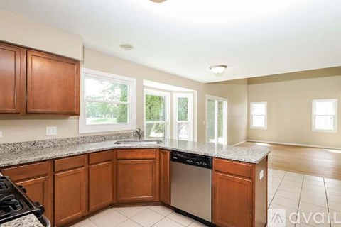 A kitchen with wooden cabinets and a granite countertop.
