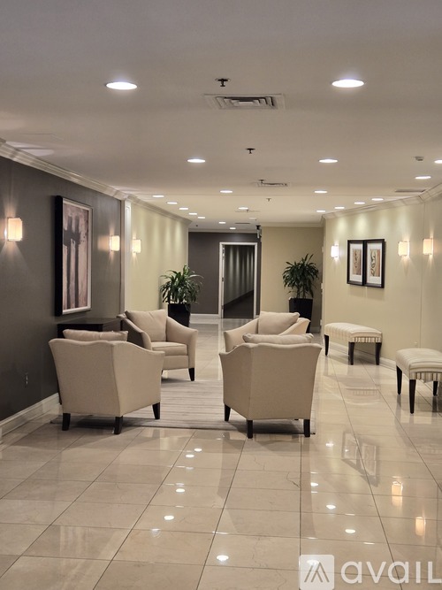 A spacious waiting area with beige chairs and a bench.