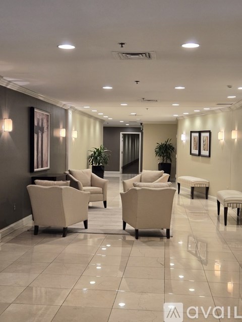 A spacious waiting area with beige chairs and a bench.