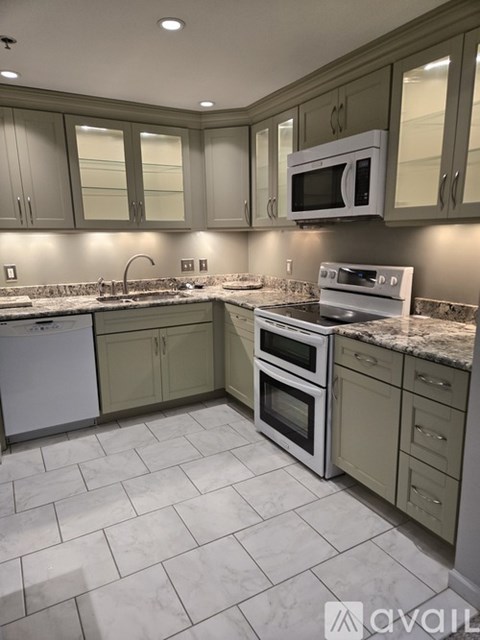 A kitchen with a white dishwasher and white oven.